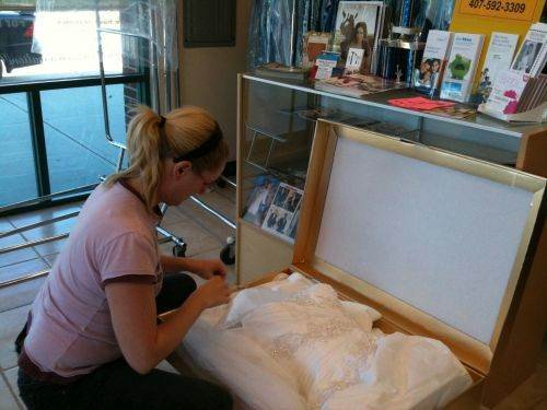 Customer inspecting Wedding Gown in Golden Box